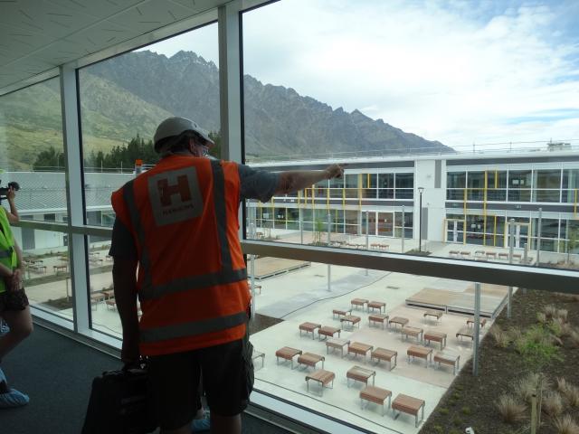 Project manager Blair Grier  points to the other side of the school above the building’s internal...