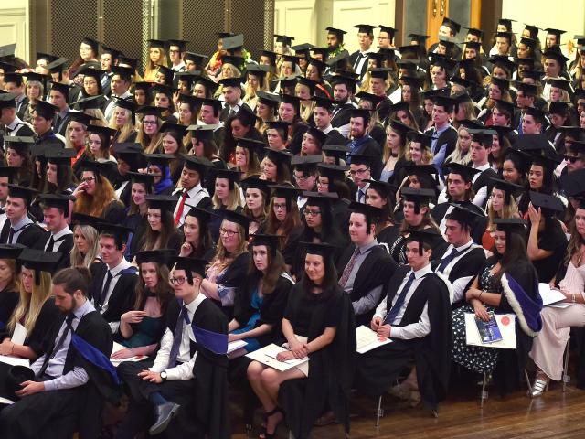 University of Otago graduates, mainly in science, listen to proceedings at the Dunedin Town Hall...