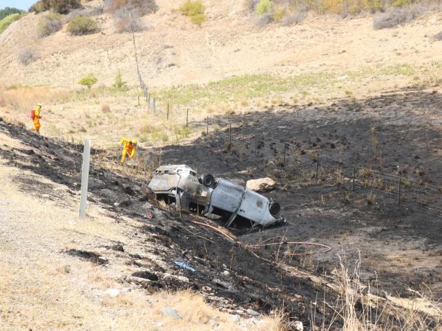 The burnt-out wreckage of the car lies upside down off the side of the road where it started a...