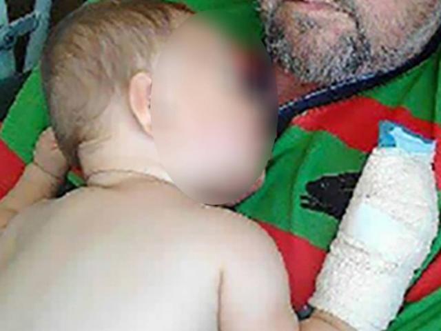 The injured baby with his grandfather shortly after the assault that left him hospitalised for a...