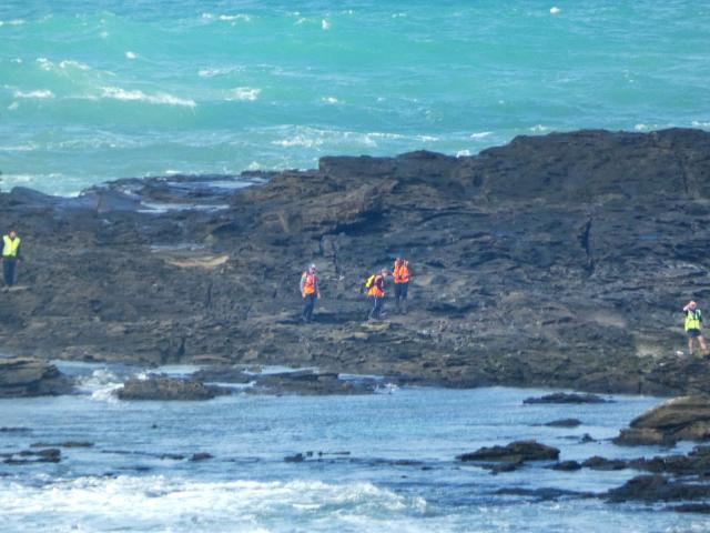 Searchers scour the rocks at Slope Point late last month. Photo: Ben Waterworth