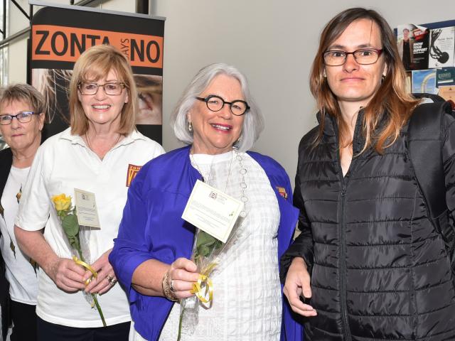 (from left) Lyn Herbert, Lyn Farry and Lynette Grave give Iloma Mollison a yellow rose yesterday...