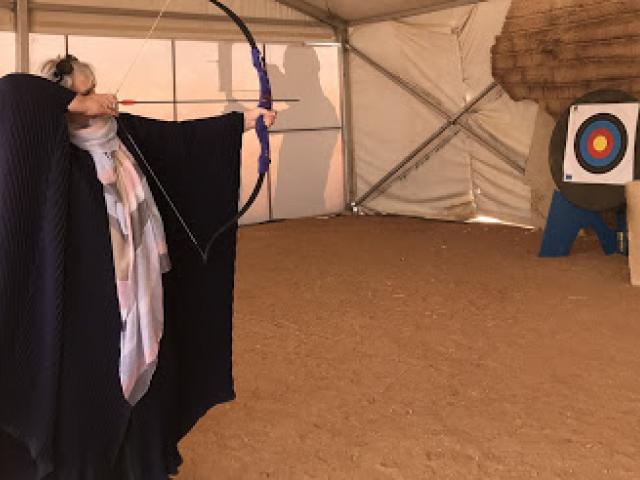 Debbie Heron tries her hand at archery while adorned in an abaya. Photo: Peter Heron