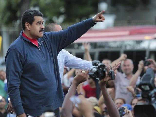 Venezuela’s President Nicolas Maduro gestures during a gathering outside Miraflores Palace in...