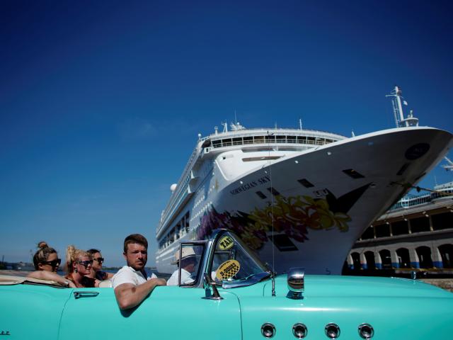 Tourists ride in a vintage car next to a cruise ship docked in Havana. Photo: Reuters