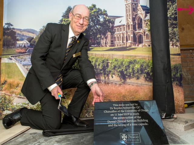 University Chancellor Dr Royden Somerville places the stone plaque to commemorate the opening of...