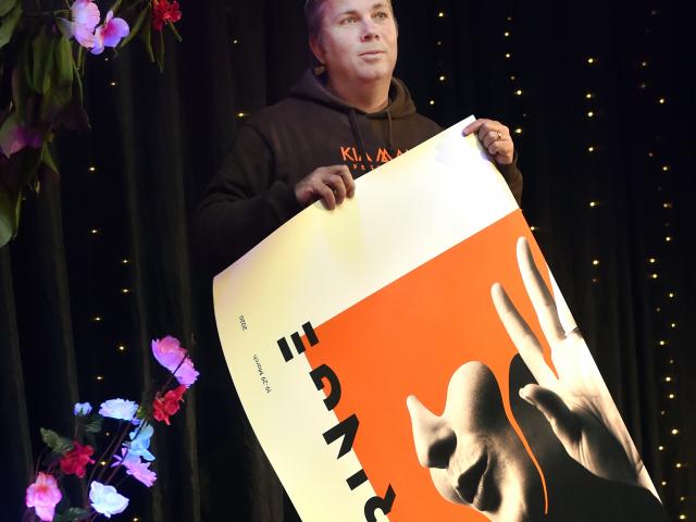 Dunedin Fringe Festival director Gareth McMillan rolls up a poster for the cancelled festival....