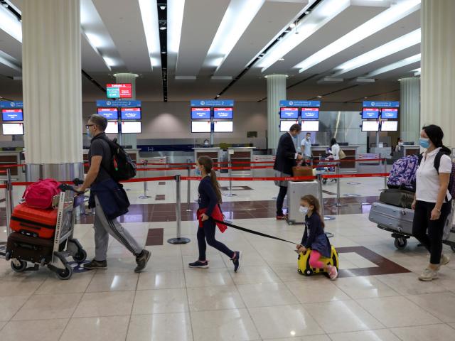 Passengers walk at Dubai International Airport as Emirates airline resumed limited outbound...
