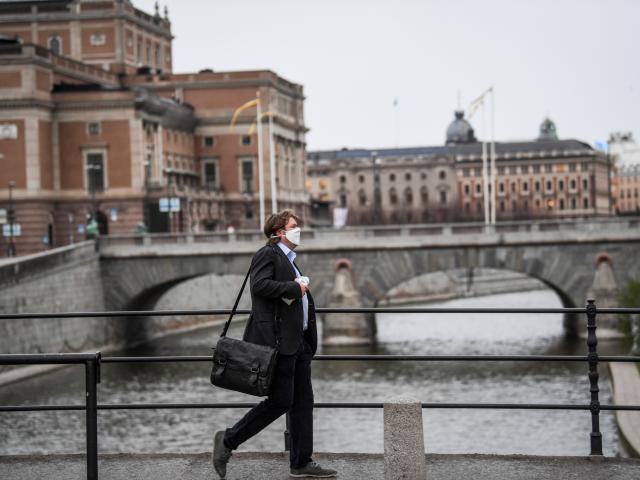 A man wearing a protective mask walks past the Royal Swedish Opera, amid the Covid-19 outbreak in...