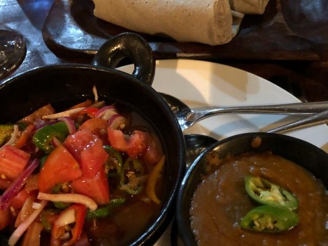 A lentil stew, tomato and red onion salad and rolled injera.