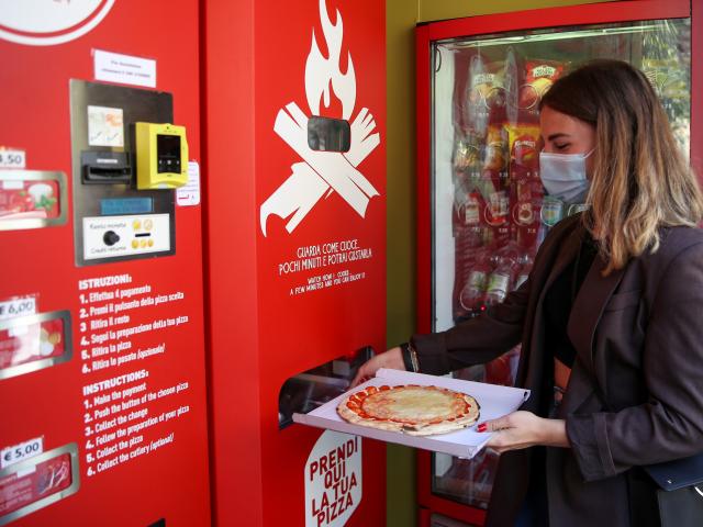 Fabrizia Pugliese collects her order at the first automatic pizza vending machine, which is...