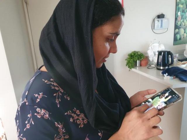 Gagandeep Kaur looking at a photo of her daughter, Nimrat, who is still in India. Photo: Katy...