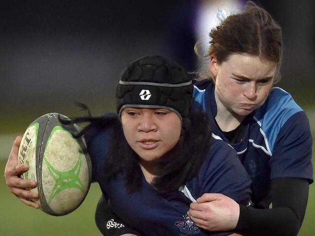 Otago Girls’ player Dinah Veituna is tackled by St Hilda’s defender Alexia Jones during the Otago...