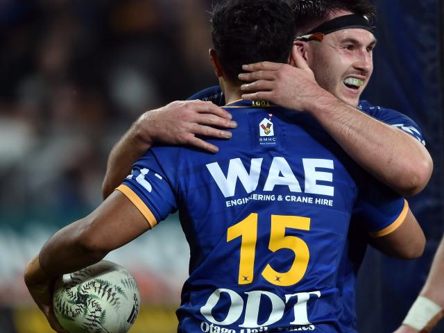 Otago fullback Josh Ioane is congratulated by hooker Ricky Jackson after scoring a try during the...