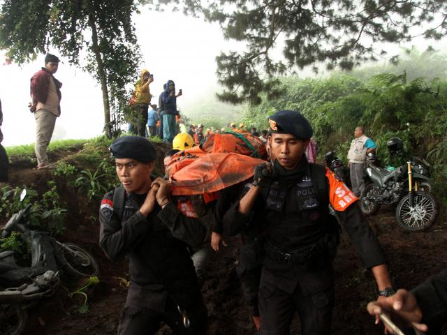 Police carry the body of a person killed in the eruption in West Sumatra province on Tuesday....