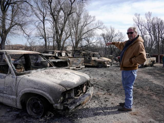 Richard Murray stands next to vehicles destroyed by the Smokehouse Creek wildfire on his property...