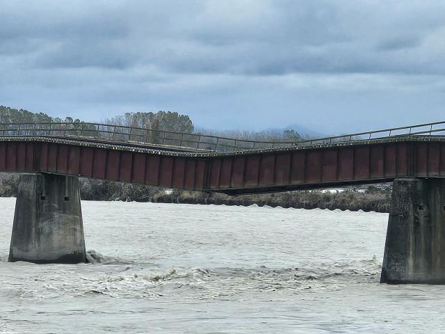 Flood waters have washed away one of the piers holding up the rail bridge over the Rangitata...
