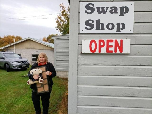 Owaka Swap Shop manager Annette Patterson holds swappable items outside the shop, as the team...