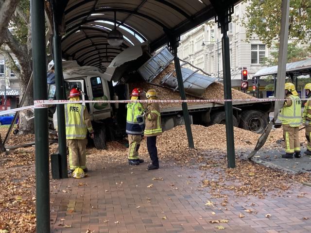 Firefighters examine the truck after it crashed through the Octagon this morning. Photos: Stephen...