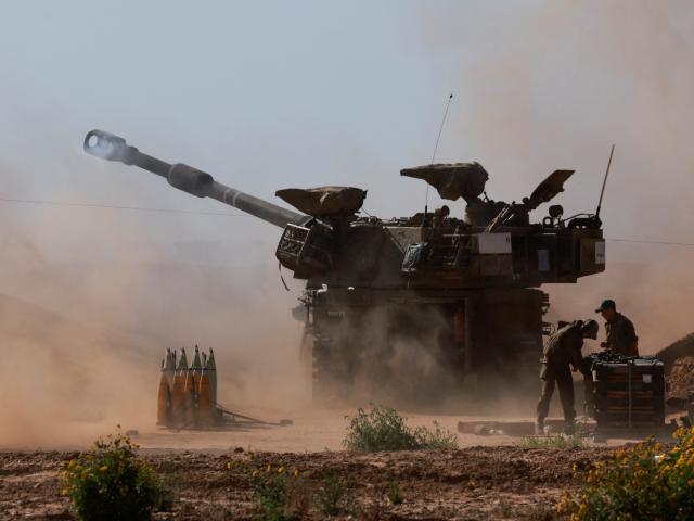 An Israeli military vehicle fires into Gaza from southern Israel. Photo: Reuters 