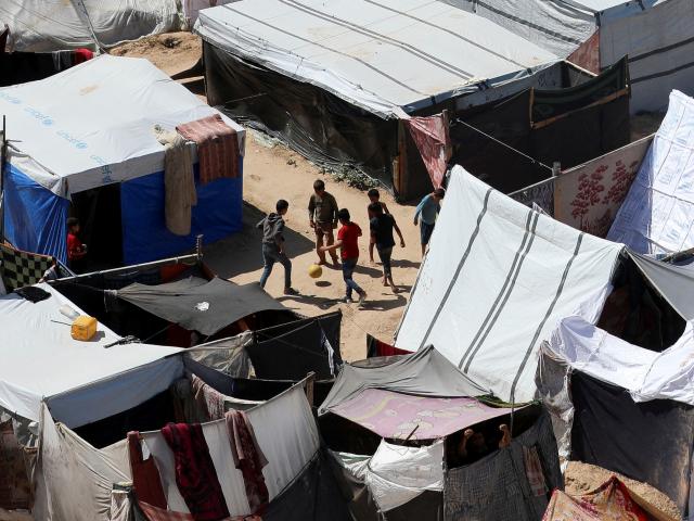 Displaced Palestinian boys play football as they shelter at a tent camp in central Gaza Strip on...