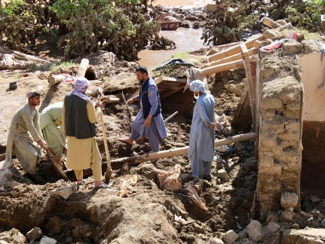 People remove debris from a flood-damaged house in Ghor Province, Afghanistan. Photo: Reuters