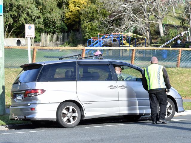 A council parking officer talks to  a driver parked in Longworth St, North East Valley, in an...