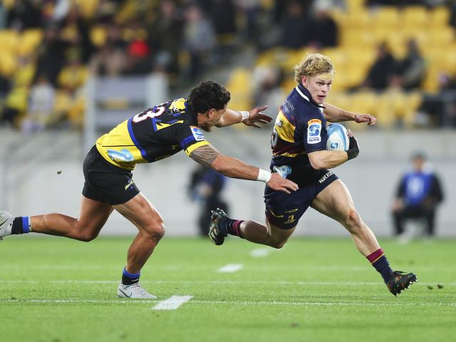 Highlanders fullback Finn Hurley tries to dance around Hurricanes centre Billy Proctor in...