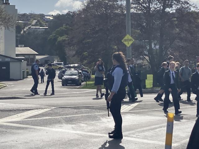 Students are escorted from the school. Photo: Stephen Jaquiery