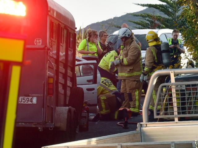 Fire fighters attend to patients from a car crash between a car and a ute towing a horse float on...