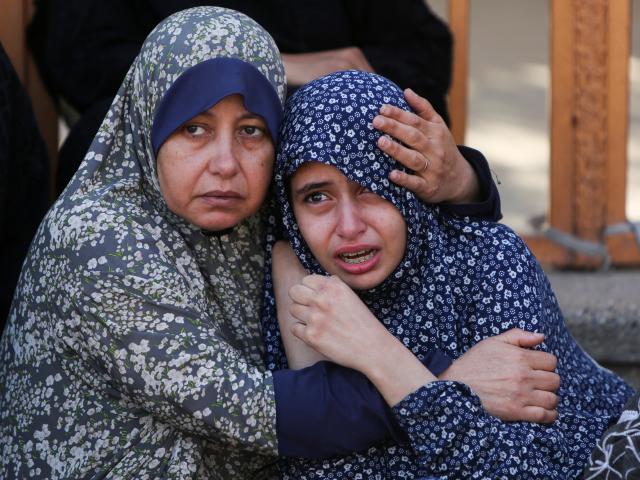 Palestinian women mourn after at least 24 people were killed by Israeli fire near an aid...
