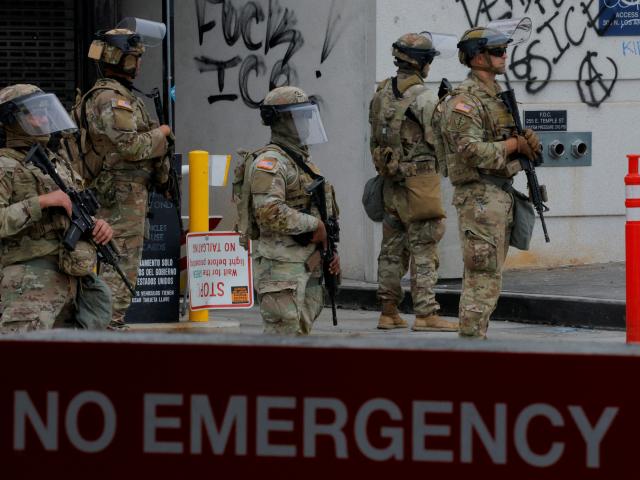 National Guard troops stand outside the Edward R. Roybal federal building, in Los Angeles. Photo:...