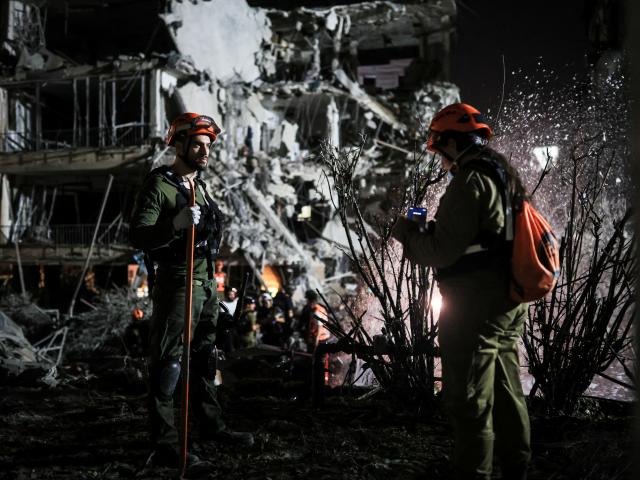 Rescue and security personnel work at an impact site following missile attack from Iran on Israel...