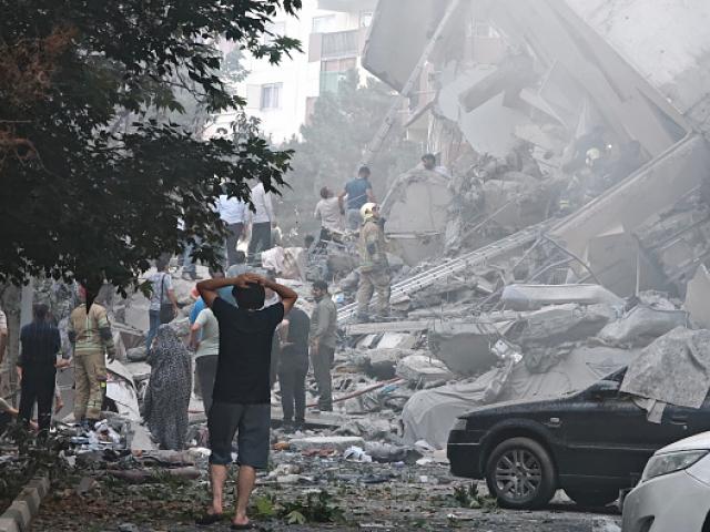 People look over damage to buildings in Nobonyad Square following Israeli airstrikes in Tehran,...