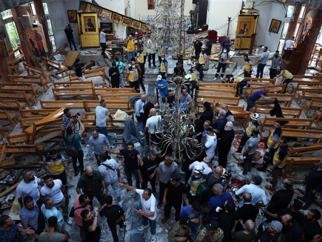 People survey the damage following a deadly blast at the Mat Elias Church in Damascus, Syria....