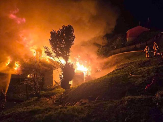 Firefighters work to extinguish a fire which tore through an Allandale Rd, Dunedin, house shortly...