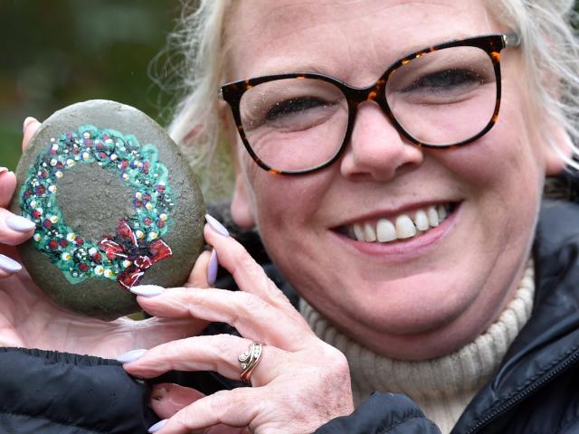 Clair Carson holds the Talyllyn Rock, which has been hidden at the Dunedin Botanic Garden after...