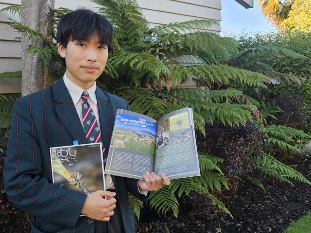 Mountainview High School international student Shou Saito shows off his published report on South...