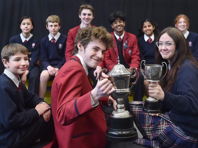 The Trinity Catholic College senior and junior debating teams  with their trophies (front, from...