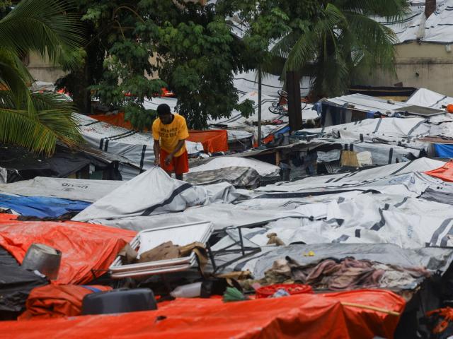 A man inspects makeshift homes during heavy rains brought by Hurricane Melissa, at a church in...
