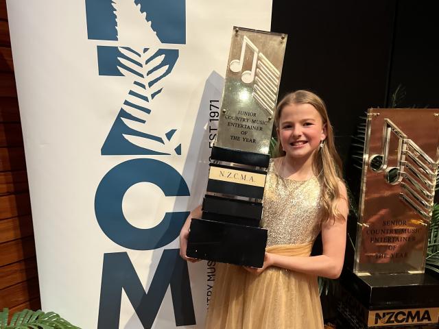 Georgia Martin, 12, holds up the Junior Country Music Entertainer of the Year trophy she won at...