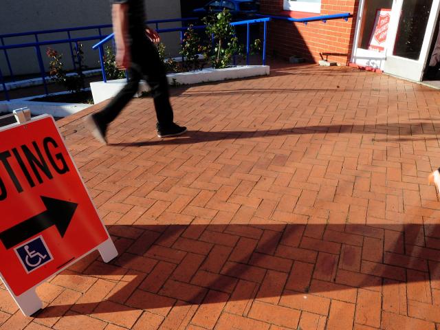 Last minute voters rush to cast their votes in South Dunedin just before closing during a...
