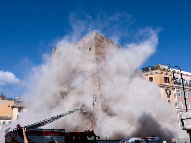 Dust rises as part of the Torre dei Conti tower collapses following an earlier partial collapse,...