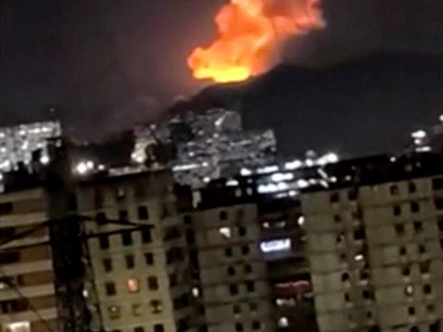 A column of smoke rises during multiple explosions in the early hours of the morning, in Caracas,...