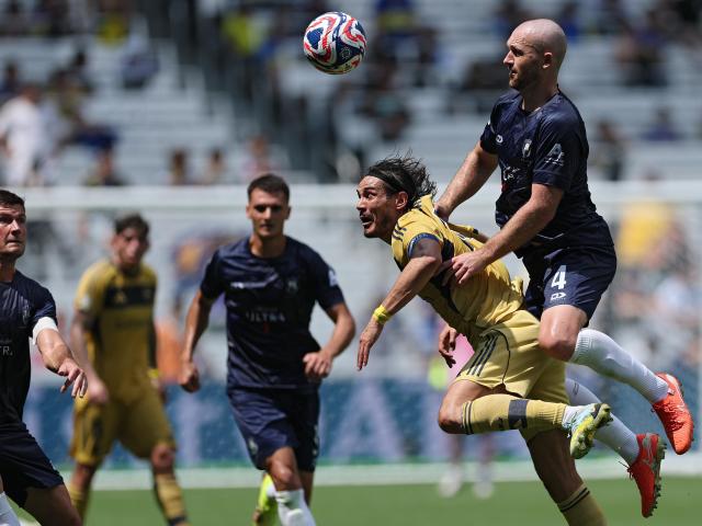 New South Island United signing Christian Gray wins a header over Uruguayan striker Edinson...