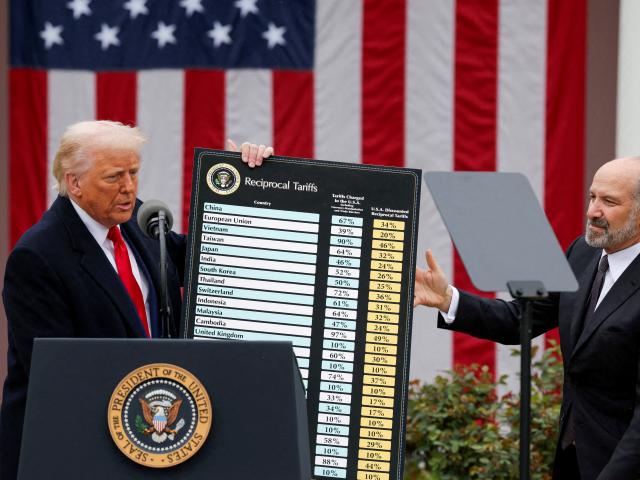 US President Donald Trump holds a chart next to Secretary of Commerce Howard Lutnick during his...