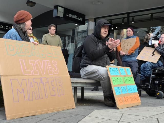 Chris Ford (with the megaphone) leads the chanting at a protest on Saturday against the...