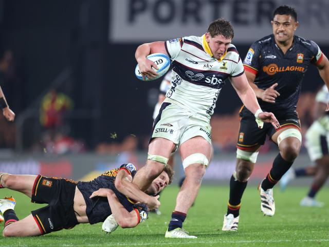Lucas Casey, of the Highlanders, is tackled by Damian McKenzie, of the Chiefs, as Tupou Vaa’i...