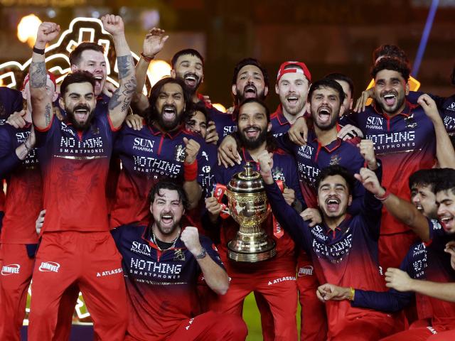 Jacob Duffy, behind Virat Kohli (with arms raised), and the Royal Challengers Bengaluru team...
