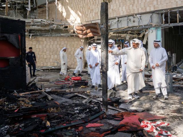 Kuwaiti officials inspect damage inside a terminal at Kuwait International Airport following a...